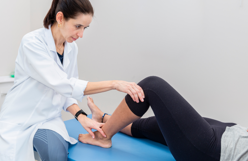 Un médico tratando la rodilla de un paciente.